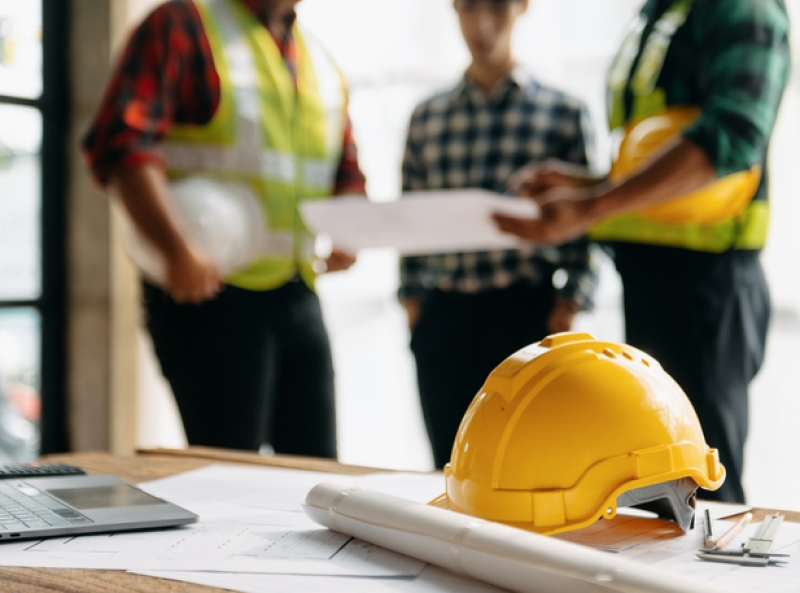 Engineer teams meeting working together wear worker helmets hardhat on construction site in modern city.Asian industry professional team