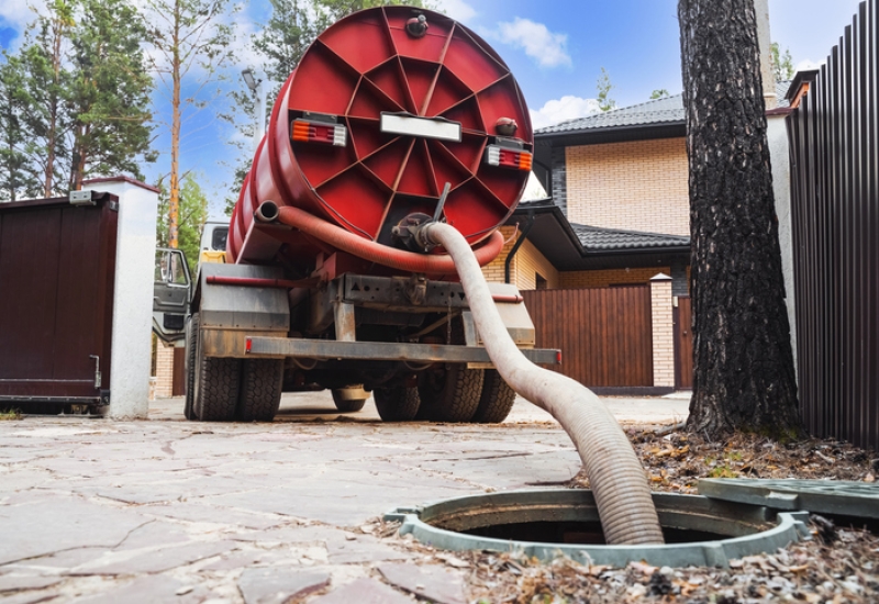 Sewer pumping machine. Septic truck. Pipe in the drainage pit. Pumping out sewage from a septic tank. Septic tank service