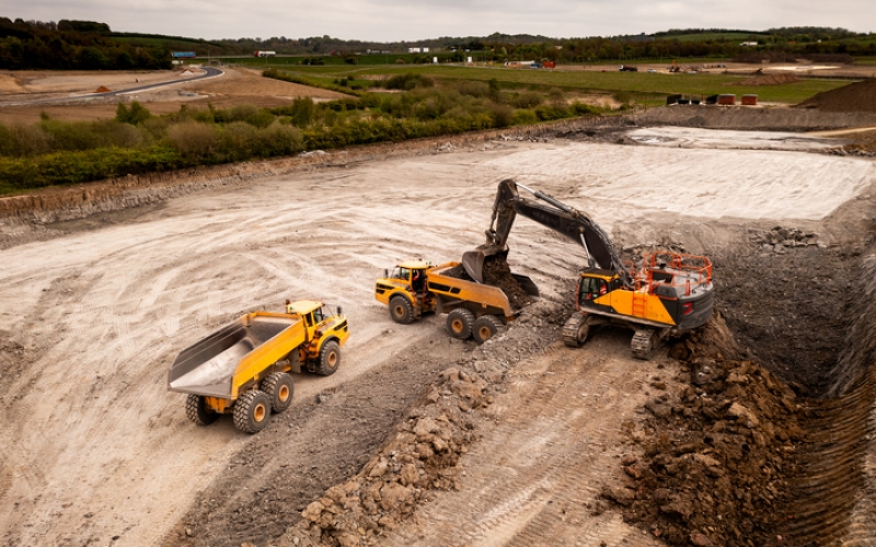 Aerial view above a digger and dumper truck on a brownfield site in the construction industry