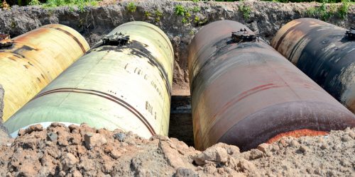 Large metal tanks are buried in the ground in the production warehouse.